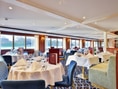 Elegantes Restaurant auf einem Schiff mit gedeckten Tischen.