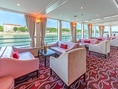 Innenraum einer Lounge mit Sofas und Blick auf einen Fluss.