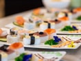 Platten mit verschiedenem Sushi und essbaren Blumen.