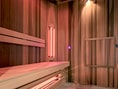 Innenraum einer modernen Sauna mit Holzverkleidung und Infrarotstrahler.