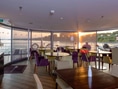 Restaurant mit Seeblick, Sonnenuntergang und leeren Tischen.