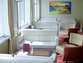Heller Lounge-Bereich mit weissen Sofas und farbigem Gemälde.