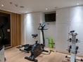 Fitnessraum mit Heimtrainer und Hanteln.