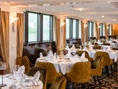 Elegantes Restaurant mit gedeckten Tischen und grossen Fenstern.