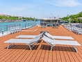 Liegestühle auf dem Deck eines Flussschiffs am sonnigen Tag.