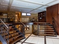 Innenraum mit eleganter Treppe und Monitoren an der Wand.