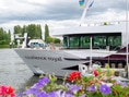 Kreuzfahrtschiff Excellence Royal auf Fluss mit Blumen im Vordergrund.
