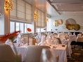 Elegantes Restaurant mit gedeckten Tischen und Blumen.