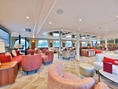 Eleganter Lounge-Bereich auf einem Schiff mit roten Sesseln.