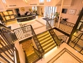 Elegante Hotel-Lobby mit Treppe und Rezeption.
