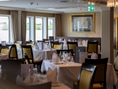 Ein Restaurant mit gedeckten Tischen und Stühlen.
