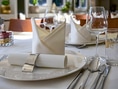 Elegant gedeckter Tisch mit gefalteter Serviette und Glas.