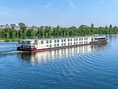 Flusskreuzfahrtschiff auf einem breiten Fluss.