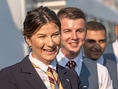 Lächelnde Personen in Uniformen stehen in einer Reihe.