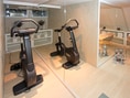 Spiegelraum mit Heimtrainer und Sessel.