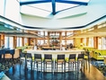 Moderne Hotelbar mit runder Theke und Barhockern.