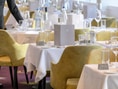 Ein Kellner richtet einen Tisch in einem eleganten Restaurant her.