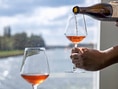 Wein wird in ein Glas am Fluss eingeschenkt.