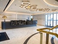 Elegante Hotellobby mit Rezeption und modernen Lampen.