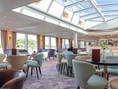 Elegantes Restaurant mit Glasdach und stilvollen Möbeln.