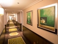 Moderner Hotelflur mit Bildern und Teppich.