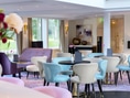 Helle, moderne Lounge mit bunten Sesseln und Tischen.