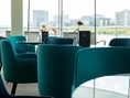 Moderne Lounge mit blauen Sesseln und Blumen.