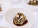 Gourmetgericht in weisser Schale mit Sauce.