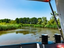 Bootsfahrt auf einem ruhigen Fluss mit Bäumen am Ufer.