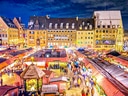 Farbenfroher Weihnachtsmarkt mit Ständen und Menschen bei Nacht.