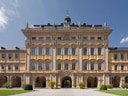 Historisches Gebäude mit gelber Fassade und Arkaden.