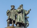 Historische Statuengruppe vor blauem Himmel.