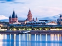 Abendliche Skyline von Mainz mit reflektierendem Fluss.