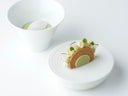 Zwei stilvolle Desserts auf weissen Tellern vor weissem Hintergrund.
