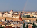 Parlamentsgebäude in Budapest mit Regenbogen im Hintergrund.