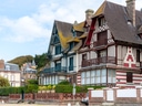 Historische Fachwerkhäuser an einer Strasse, mit blauem Himmel.