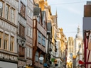 Schmale Strasse mit Fachwerkhäusern und Kirche im Hintergrund.