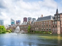 Historische Gebäude am Wasser mit Springbrunnen in Den Haag.