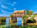 Mittelalterliches Haus auf Brücke über Fluss.