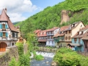 Malerisches Dorf mit Fachwerkhäusern entlang eines Baches.