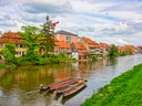 Fluss mit Booten und historische Häuserreihe.