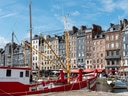 Boote im Hafen vor bunten Gebäuden.