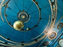 Blaue Decke mit astronomischen Markierungen und goldener Kugel.