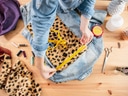 Person misst Stoff auf Jeansjacke mit Massband.