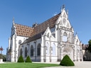 Gotische Kathedrale mit buntem Dach bei sonnigem Himmel.