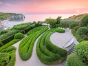 Schöne Gartenanlage mit Blick auf Küste bei Sonnenuntergang.