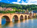 Alte Brücke und Schloss in Heidelberg mit Fluss und Hügeln.