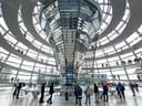 Menschen gehen in einer gläsernen Kuppel mit spiralförmigen Gehwegen.