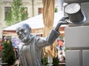 Bronzestatue eines Mannes mit Zylinder in der Stadt.