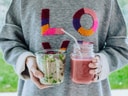 Person hält Salat im Glas und Smoothie im Mason-Jar.